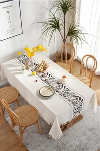 Close-up of zebra pattern print and white pom-pom fringe on linen tablecloth