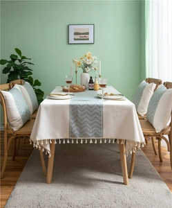Detail of woven polyester tablecloth featuring green wave pattern and white fringe edge
