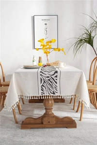 Close-up of geometric zebra pattern and white tassel fringe on linen rectangle tablecloth