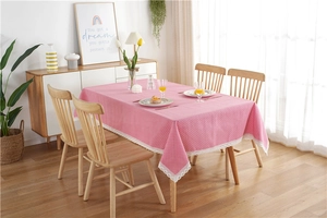 Detail of pink polka dot tablecloth featuring elegant white lace edges and soft fabric