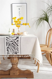Close-up of geometric zebra stripes and cotton tassel fringe on cotton linen tablecloth