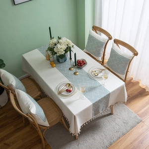 Detailed view of jacquard table runner with geometric patterns and fringe tassels