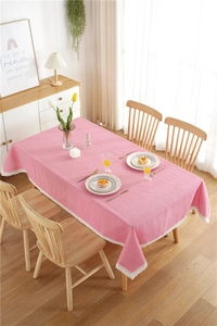 Close-up of pink polka dot tablecloth with elegant white lace edges on a wooden table
