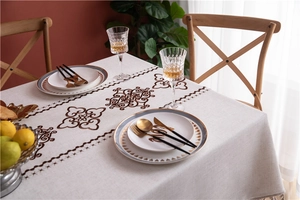 Detailed embroidery of brown floral patterns on beige linen rectangular tablecloth