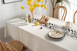 Detail of embroidered zebra print tablecloth with elegant white fringe tassels
