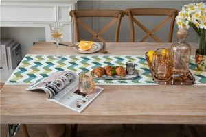 Close-up of green jacquard chenille table runner with fishbone pattern and lace trim