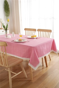 Detailed view of pink polka dot tablecloth with delicate white lace border edge