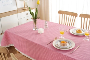 Close-up of pink polka dot tablecloth with intricate white crochet lace border detail