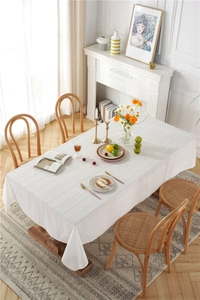 Detailed macro view of white floral lace tablecloth with hollow embroidery pattern