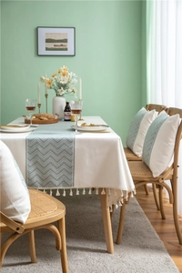 Close-up of wavy jacquard pattern and elegant fringe tassels on a poly-linen tablecloth