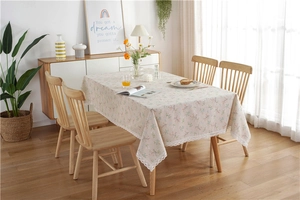 Detailed close-up of pastoral floral tablecloth with white crochet lace edges