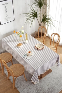 Detail of gray and pink plaid tablecloth featuring delicate white tassel fringe edges