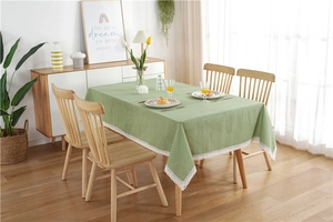 Detailed view of green polka dot tablecloth with elegant white hollow lace border