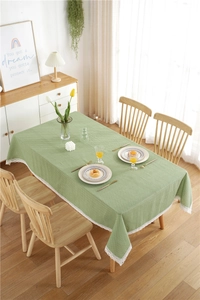 Detailed view of green polka dot tablecloth with delicate white lace border edge