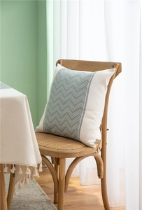 Detailed view of square boho cushion with grey-green wave pattern on woven fabric