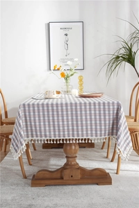 Detail of grey and pink checkered tablecloth with white pom-pom tassel fringe trim