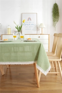 Close-up of light green polka dot tablecloth featuring delicate white lace edge detailing