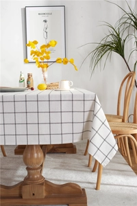 Detail of minimalist black and white grid tablecloth draped over a wooden table