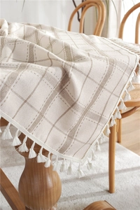 Detailed view of Nordic beige plaid tablecloth featuring elegant cotton fringe tassels