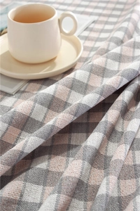 Detailed close-up of grey and pink checkered tablecloth fabric with silver thread weaving