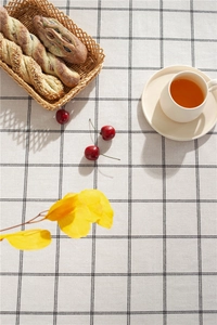 Detail of black and white checkered tablecloth with woven texture and cafe style setting