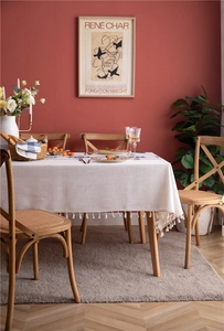 Detail of light beige embroidered tablecloth with tassels and blue floral patterns
