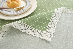 Detailed close-up of green polka dot tablecloth with white crochet lace edges