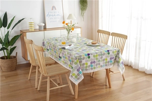 Detailed view of colorful leaf pattern fabric with white crochet lace border on table