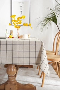 Detailed close-up of gray checkered linen tablecloth with texture on a wooden table