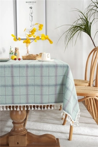 Detail of mint green plaid tablecloth with cotton linen texture and white fringe edges