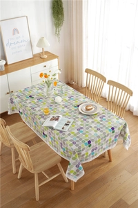 Close-up of colorful leaf patterns and elegant white lace edging on a rectangular tablecloth