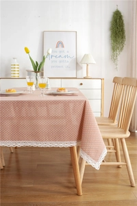 Detail of pink polka dot tablecloth with white lace edges in a cozy home setting