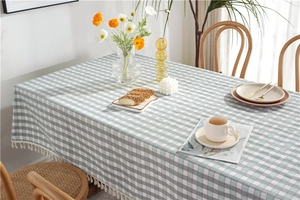 Detail of green gingham plaid tablecloth with white fringe edges and soft texture