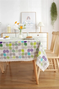Close-up of colorful leaf patterns and elegant white lace borders on tablecloth