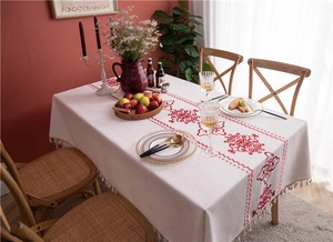 Detailed view of bohemian floral tablecloth with tassels and red symmetrical patterns