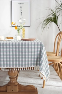 Detailed close-up of grey and white checkered tablecloth with delicate white fringe tassels