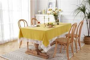 Detailed view of yellow cotton rectangular tablecloth featuring elegant white lace edges