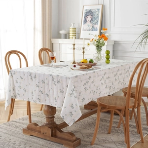 Pastel floral cotton tablecloth with geometric jacquard on a wooden dining table