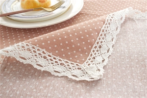 Close-up of pink polka dot tablecloth with delicate white lace edging and fabric texture