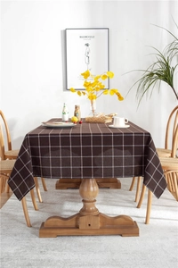 Macro detail of dark brown plaid tablecloth with white grid pattern on a wooden table