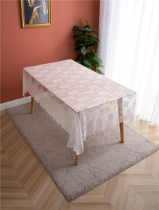 Close-up of white French lace tablecloth with intricate floral patterns and scalloped edges