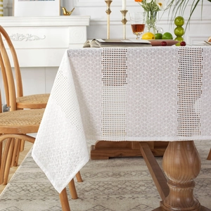 White French lace tablecloth with hollow crochet pattern on a wooden dining table