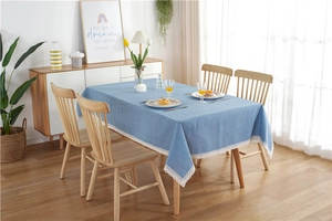 Detail of light blue polka dot tablecloth with white lace edges on a wooden table