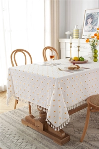 Detail of white rectangle tablecloth with yellow polka dots and white tassel fringes