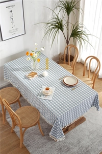 Close-up of blue and white plaid tablecloth with elegant white cotton tassels