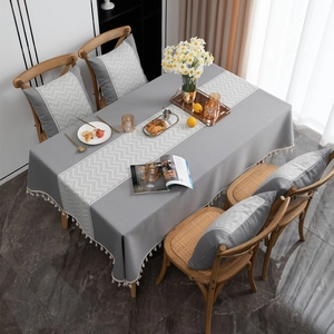 Gray jacquard tablecloth with chevron pattern and white fringe in a Nordic style setting