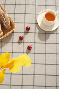 Close-up of cotton linen tablecloth with dark gray double-line grid pattern and tassels