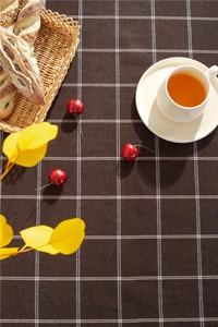 Detailed texture of coffee-colored checkered cotton tablecloth with cozy cafe aesthetic