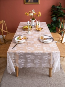 Detail of white French lace tablecloth with floral patterns and eyelash lace edges