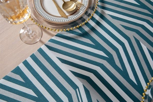 Detail of chenille table runner with geometric chevron pattern and gold beaded place setting